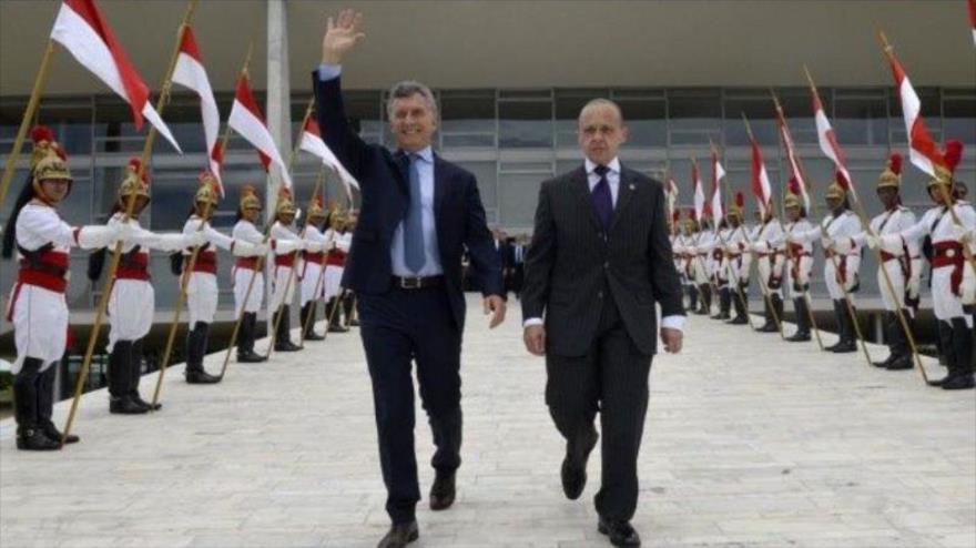 El presidente de Argentina, Mauricio Macri (izq.), saluda muy alegremente a una "supuesta multitud", Brasilia, 7 de febrero de 2017.