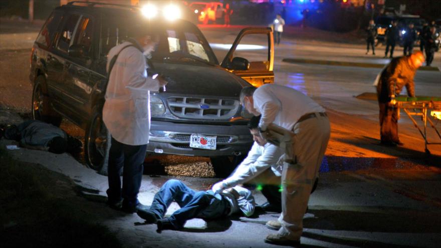 Personal forense cerca de un cuerpo en una escena del crimen organizado tras un disparo en el vecindario de Villa Juárez en Navolato, estado de Sinaloa, México, 7 de febrero de 2017.