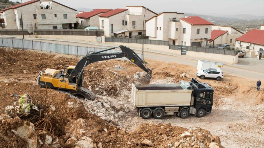 Una excavadora israelí prepara el terreno para construir nuevas viviendas en el asentamiento ilegal Ariel, en Nablus, Cisjordania, 25 de enero de 2017.