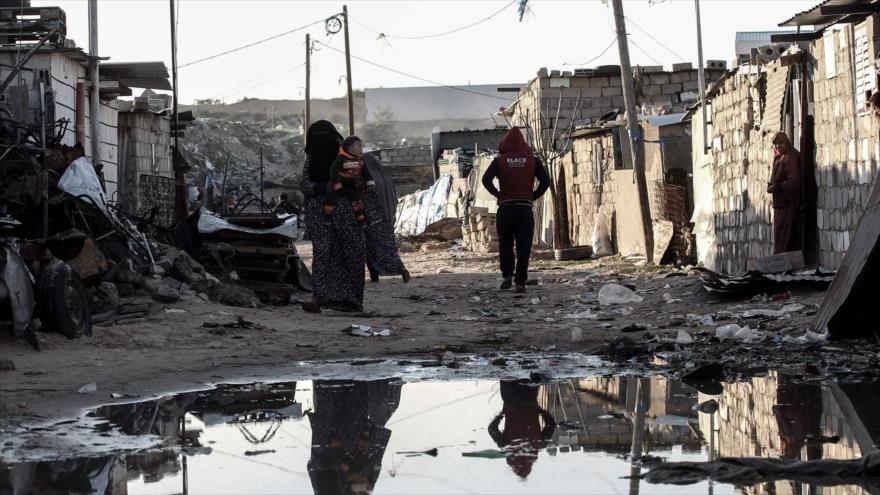Palestinos caminan por una calle en una zona empobrecida de la ciudad de Jan Yunis, en el sur de la Franja de Gaza, 19 de febrero de 2017. 
