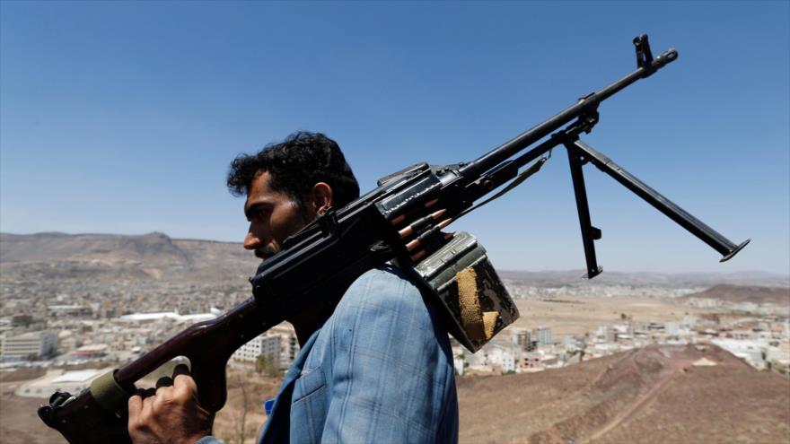 Un combatiente del movimiento popular yemení Ansarolá sostiene un rifle de fabricación canadiense.