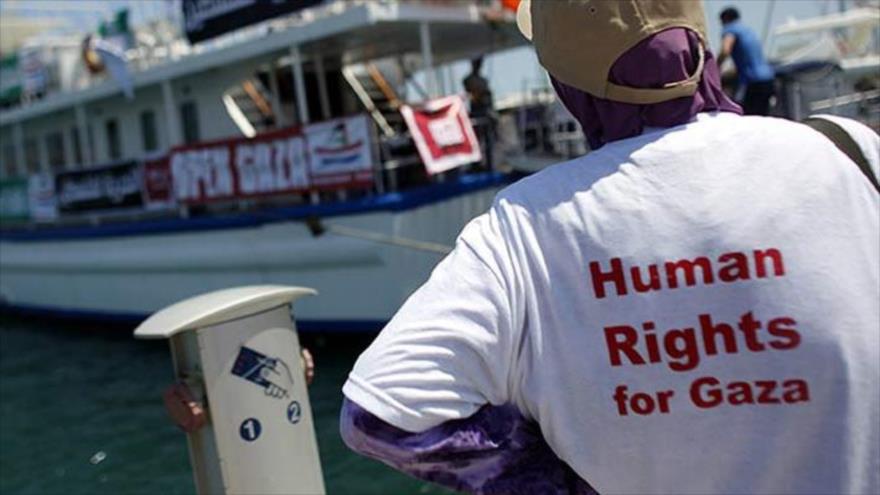 Una activista mira el barco de la ayuda para la franja de Gaza.
