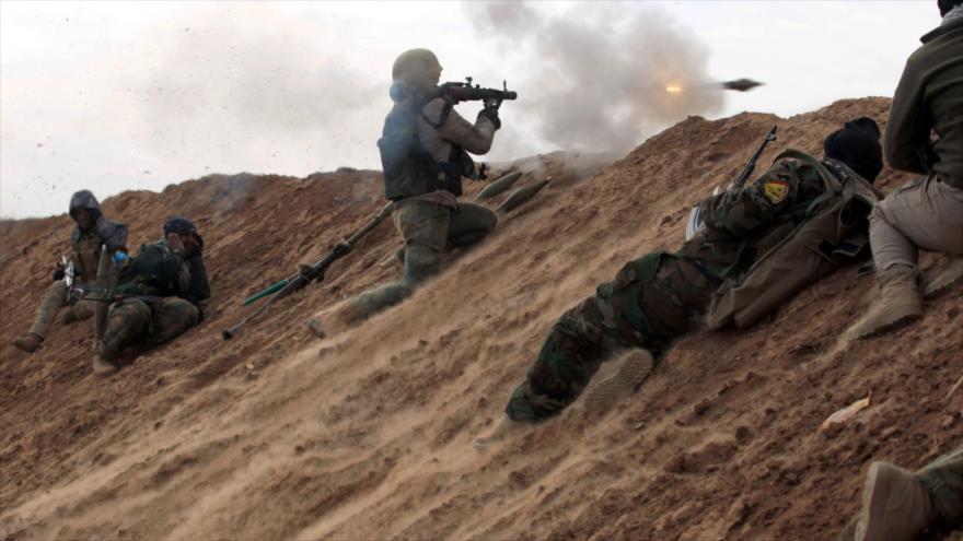 Los combatientes de Al-Hashad al-Shabi apuntan contra posiciones del pueblo de Shwah, en el sur de la ciudad de Tal Afar, en las afueras occidentales de Mosul, 13 de diciembre de 2016.