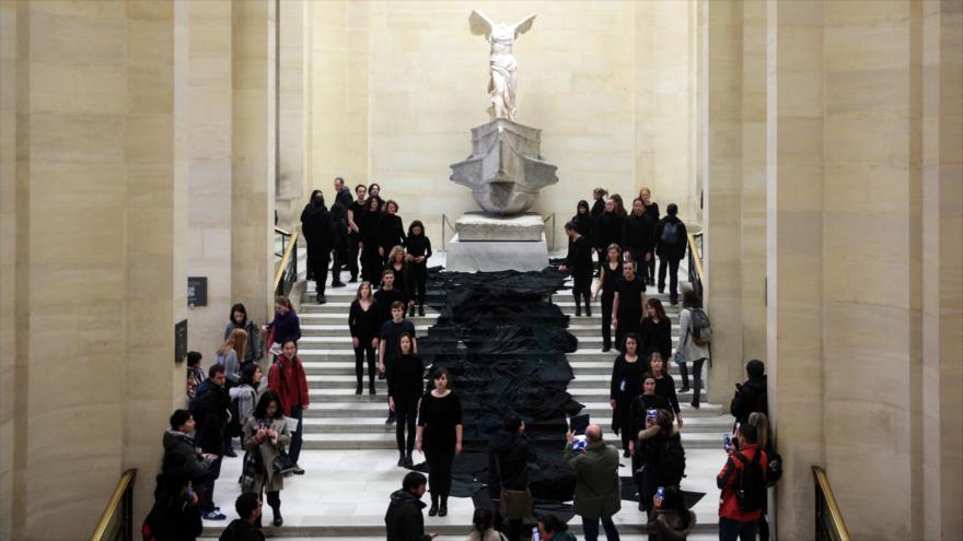 Militantes ecologistas escenifican el vertido de un río de petróleo a los pies de la estatua helenística conocida como ‘Victoria alada de Samotracia’, en el parisino museo del Louvre, 5 de marzo de 2017.