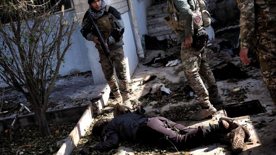 Fuerzas iraquíes se encuentran al lado del cuerpo de un terrorista en su avance hacia la ciudad norteña de Mosul, 5 de marzo de 2017.