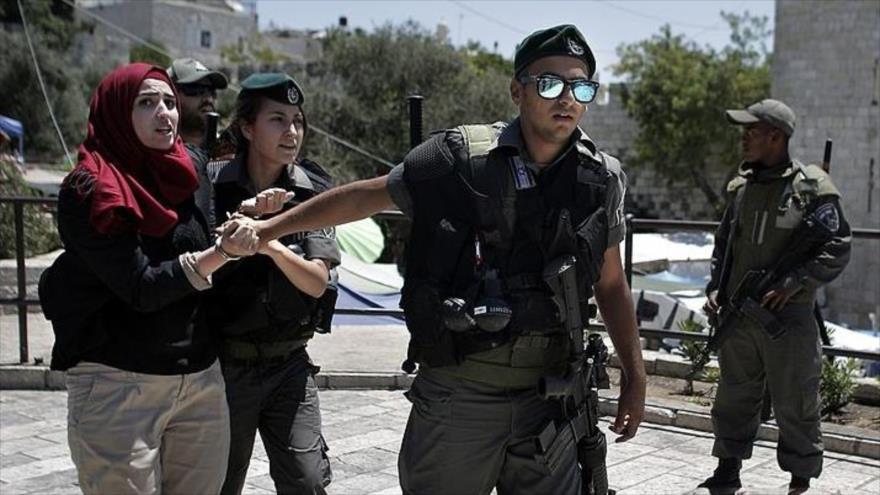 Soldados israelíes detienen a una mujer palestina en la ciudad de Al-Quds (Jerusalén), 24 de julio de 2014. 