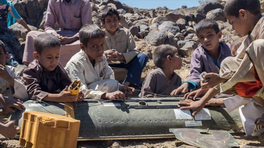 Niños yemeníes reunidos alrededor de los restos de una bomba de racimo CBU-58 usada por Arabia Saudí contra su país.