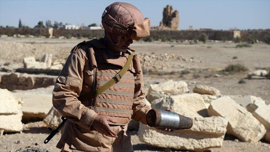 Un soldado ruso inspecciona un proyectil de mortero en las afueras de la ciudad histórica de Palmira, en la provincia de Homs (centro de Siria).