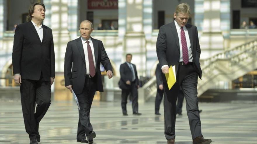 El presidente de Rusia, Vladimir Putin (centro), el portavoz del Kremlin, Dmitri Peskov (derecha), y Konstantin Ernst, director general del Canal Uno de Rusia.