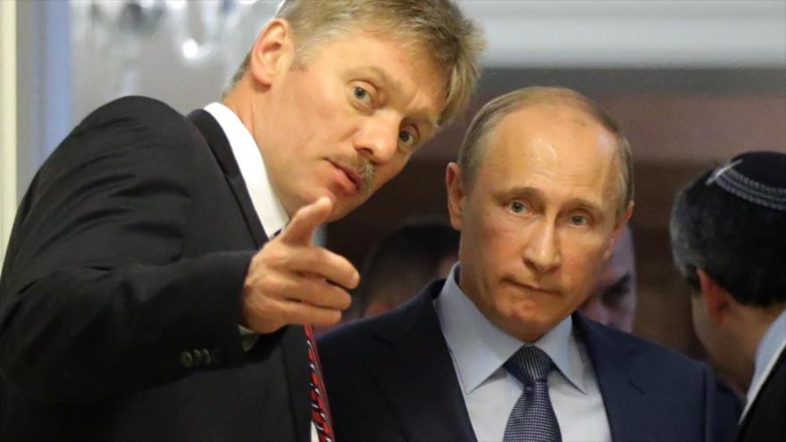 El portavoz del Kremlin, Dmitri peskov, (izda.) y el presidente ruso, Vladimir Putin.