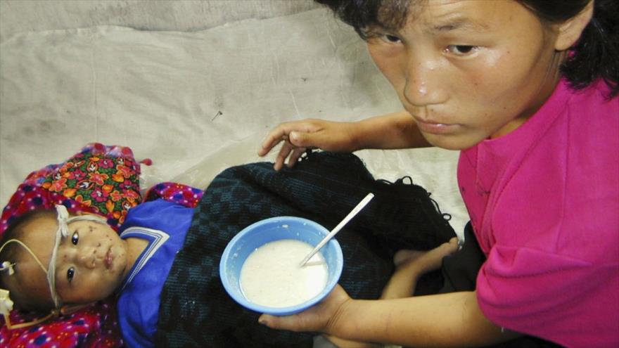 Una mujer norcoreana alimenta a su hijo.