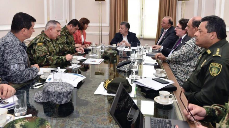 El presidente de Colombia, Juan Manuel Santos (centro), se reúne en Bogotá con la canciller, María Ángela Holguín (primera de la izqda.), el ministro de Defensa, Luis Carlos Villegas (primero de la dcha.), y miembros de la Policía Nacional y las fuerzas del Ejército, 23 de marzo de 2017.