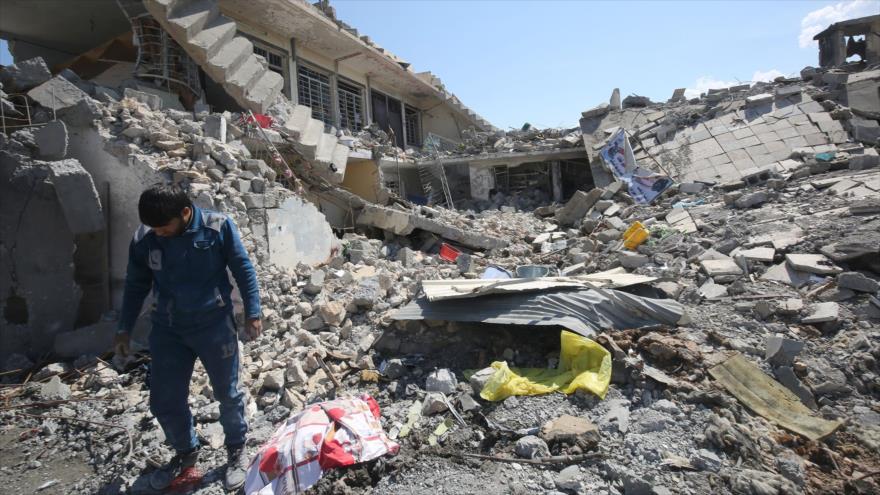 Un iraquí inspecciona los daños causados por los ataques de la llamada coalición anti-EIIL liderada por EE.UU. en la zona de Al-Jadida, en el oeste de la ciudad de Mosul (norte de Irak), 26 de marzo de 2017.