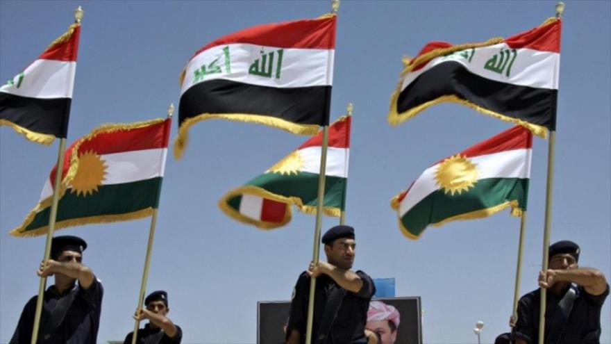 Varias banderas nacionales de Irak (en primer plano) son portadas por los soldados en Kirkuk, y otras tantas de la región semiautónoma de Kurdistán.