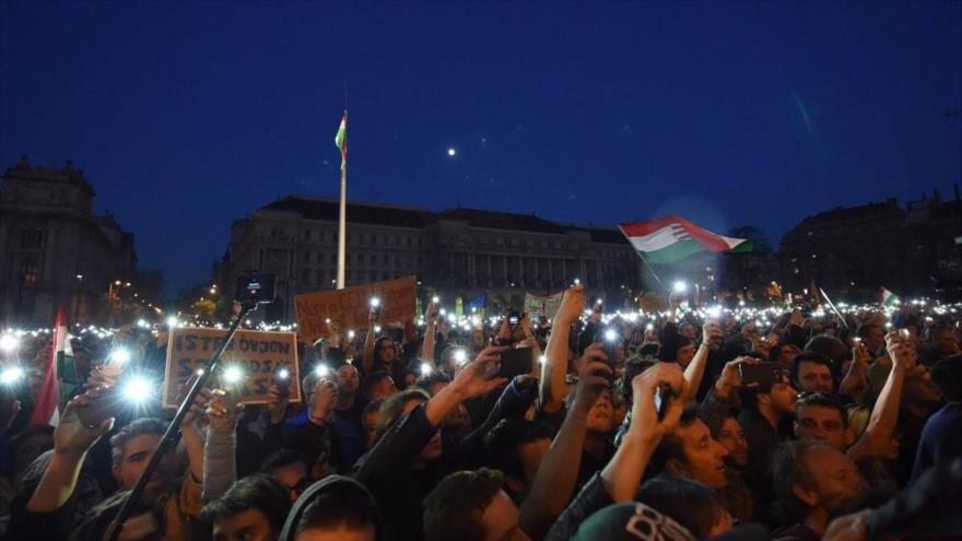 Los manifestantes húngaros mantienen sus teléfonos móviles iluminados en el aire, instando al presidente Janos Ader a no firmar la enmienda, Budapest, 9 de abril de 2017.
