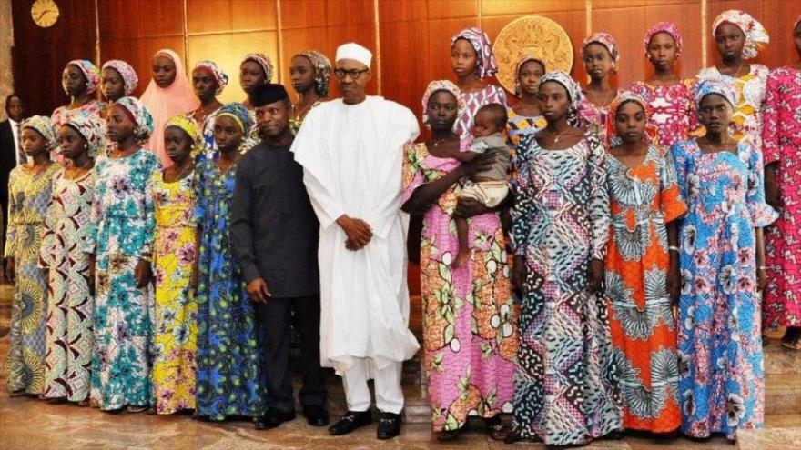 El presidente nigeriano, Muhammadu Buhari, posa para una fotografía junto a las 21 estudiantes de Chibok, liberadas por el grupo terrorista Boko Haram, 19 de octubre de 2016.
