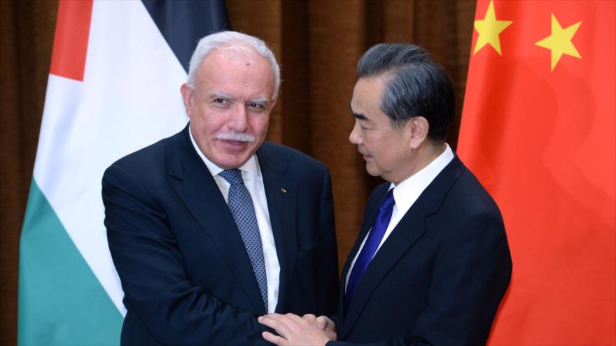 El canciller palestino, Riad al-Maliki (izda.), y el de China, Wang Yi, se dan la mano tras reunirse en Pekín, capital china, 13 de abril de 2017.
