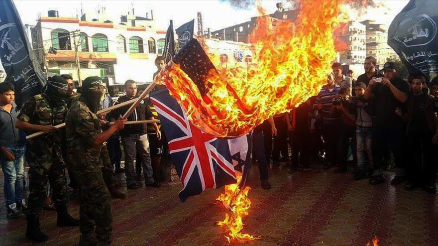 Palestinos queman las banderas de EE.UU. y del Reino Unido durante una protesta en el aniversario de la Declaración de Balfour.