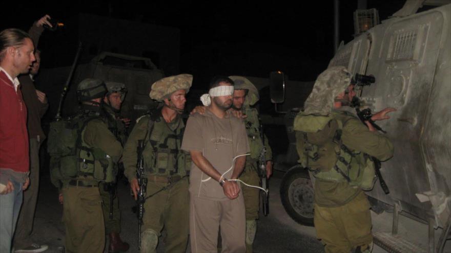 Soldados israelíes trasladan a un preso en la ocupada Cisjordania.
