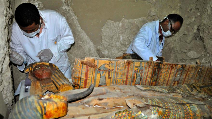 Miembros de un equipo arqueológico egipcio trabajan en un ataúd de madera descubierto en una tumba de 3500 años de antigüedad cerca de la ciudad egipcia de Luxor, 18 de abril de 2017. 