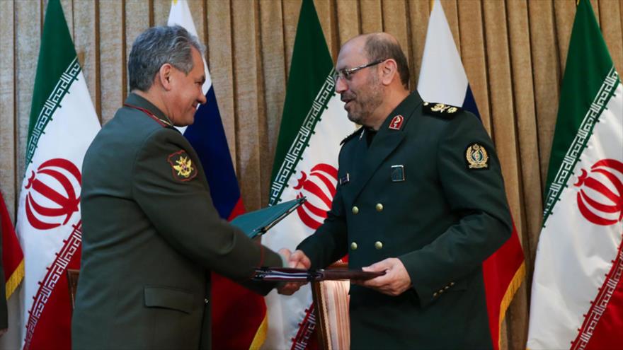 Los ministros de Defensa de Irán y Rusia, el general de brigada Husein Dehqan (dcha.), y Serguei Shoigu, respectivamente, se estrechan la mano durante una visita en Teherán, capital persa, en 2015.