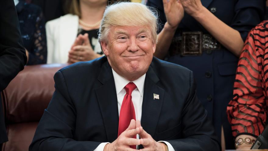 El presidente de EE.UU., Donald Trump, sonríe durante un evento para elegir al profesor del año en su despacho, el Salón Oval de la Casa Blanca, 26 de abril de 2017.