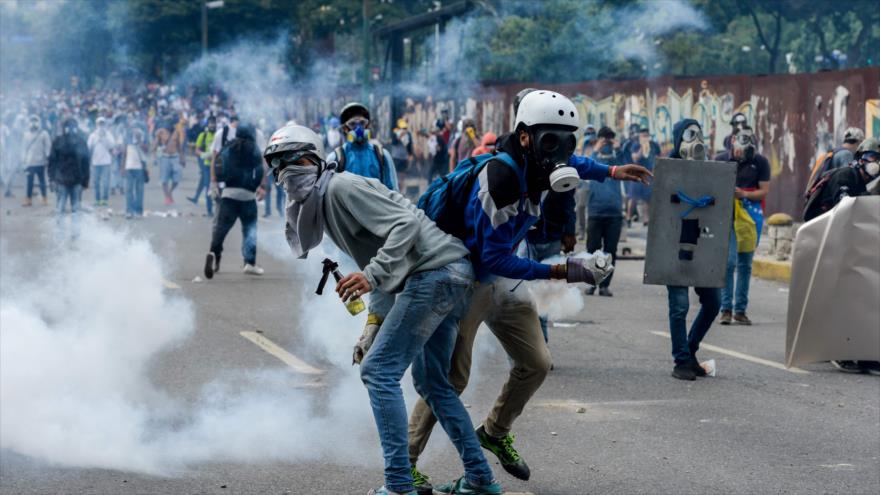 Manifestantes opositores chocan con la policía antidisturbios de Venezuela durante una marcha de protesta en Caracas, 26 de abril de 2017.