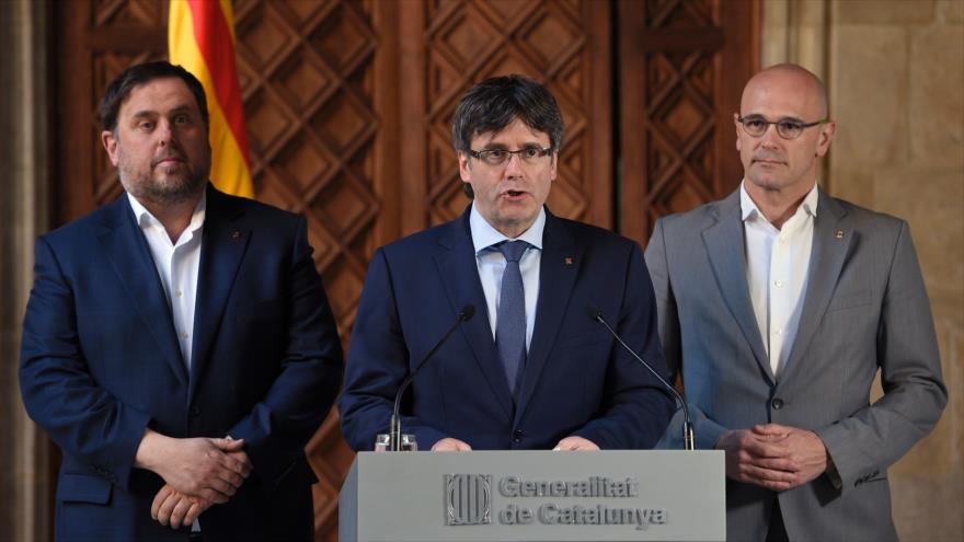 El presidente del Gobierno regional catalán, Carles Puigdemont (centro), lee una declaración oficial a los medios de comunicación en Barcelona, 13 de marzo de 2017.