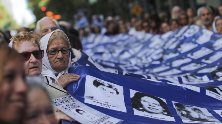Madres y Abuelas de Plaza de Mayo portan una pancarta con las fotografías de sus seres queridos desaparecidos durante la dictadura argentina.