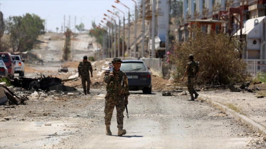 Miembros de las Fuerzas Democráticas Sirias (FDS), apoyadas por EE.UU., vigilan las calles de la ciudad siria de Al-Tabqa, 12 de mayo de 2017.