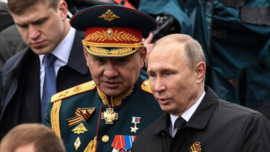 El presidente ruso, Vladimir Putin (dcha.), y el ministro de Defensa Sergei Shoigu caminan en la Plaza Roja después del desfile militar del Día de la Victoria en Moscú, 9 de mayo de 2017.