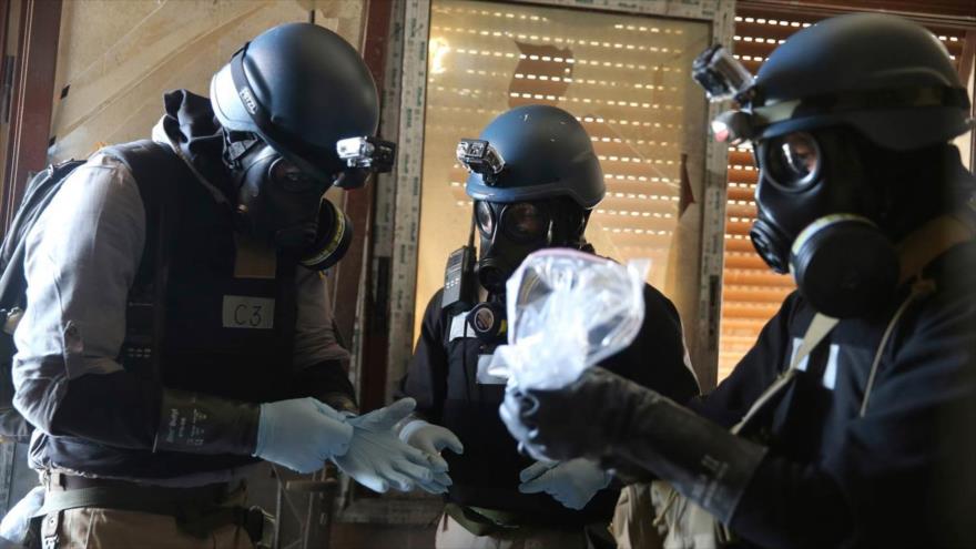 Un experto en armas químicas de la ONU, que lleva una máscara de gas, tiene una bolsa de plástico que contiene muestras tomadas en uno de los sitios de un presunto ataque con armas químicas en Damasco, capital siria, 29 de agosto de 2013.