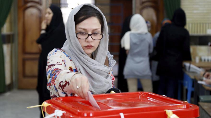 Una mujer iraní emite su voto para los comicios parlamentarios en un colegio electoral en la ciudad de Quds, cerca de Teherán (capital), 29 de abril de 2016.