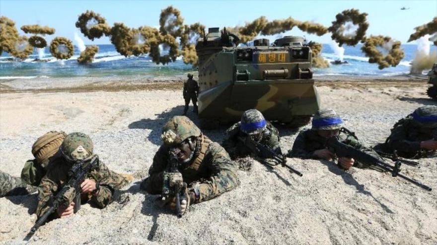 Soldados de la Marina estadounidense y los del Ejército de Corea del Sur (llevan banda azul sobre su casco), durante un ejercicio militar en una playa de la península coreana.