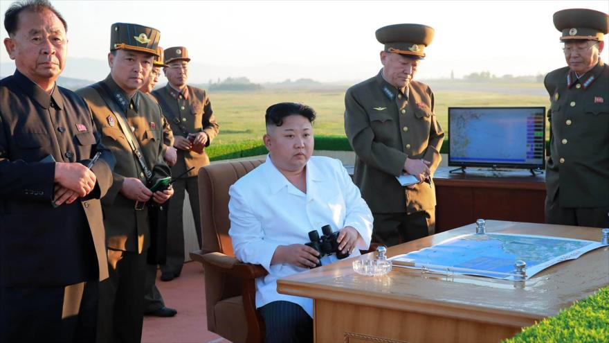 El líder de Corea del Norte, Kim Jong-un (centro), sigue de cerca la prueba de un sistema antiaéreo en un lugar no identificado.