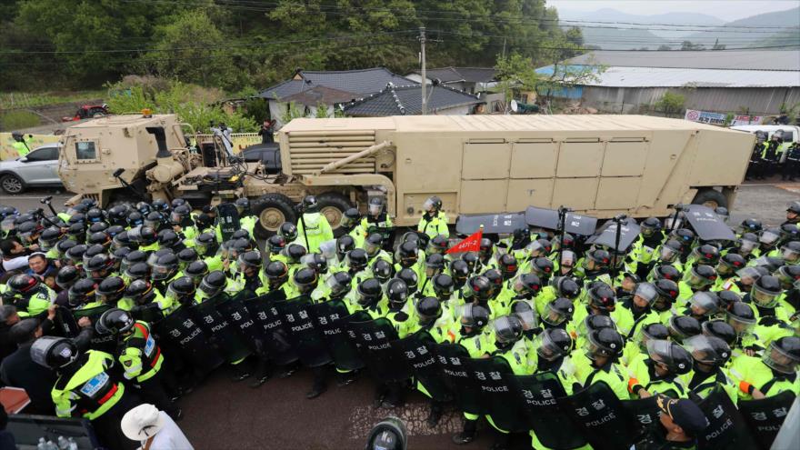Los manifestantes y la policía surcoreanos aguardan que los remolques que llevan los lanzadores del sistema antimisil THAAD entren en un sitio de despliegue en Seongju, 26 de abril de 2017.