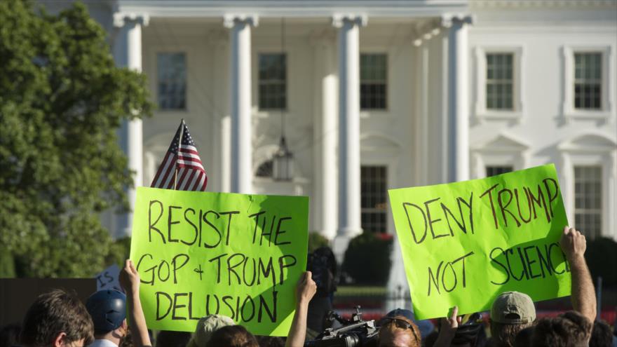 Manifestantes sostienen pancartas durante una manifestación contra la decisión de Trump de retirar a EE.UU. del acuerdo climático de París frente a la Casa Blanca en Washington, 1 de junio de 2017.