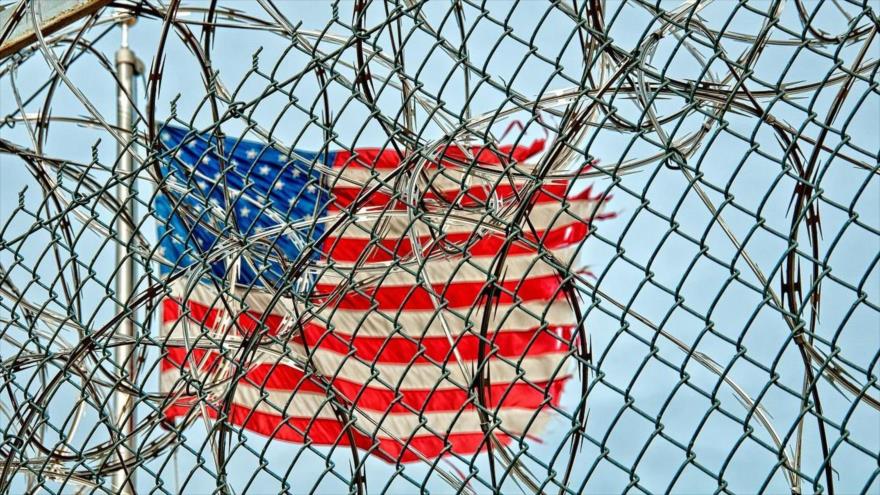 Una bandera de EE.UU. ondea detrás de los alambres de púa del centro de detención militar de Guantánamo.