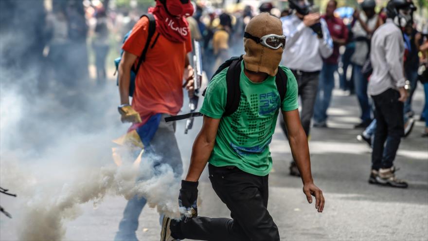 Opositores venezolanos disparan a la prensa para no ser grabados