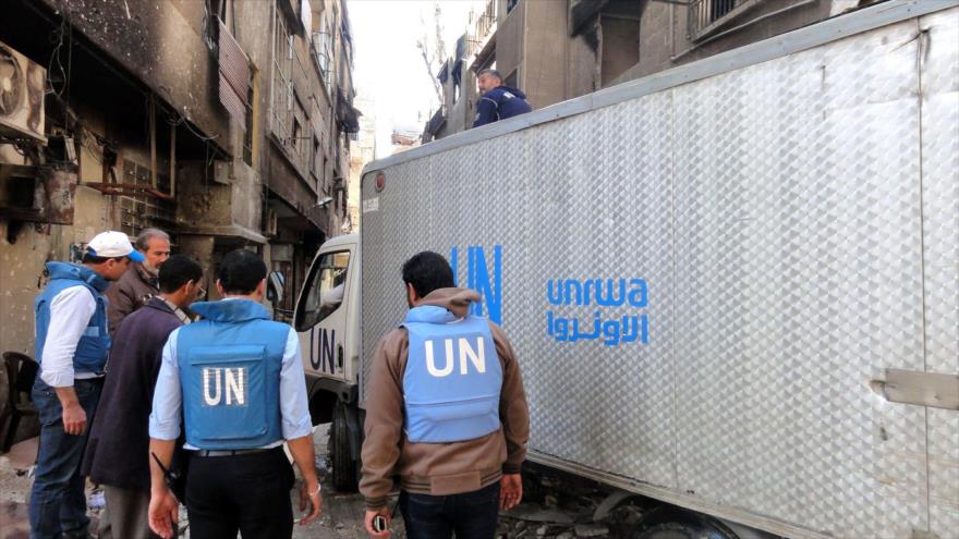 Agentes de la UNRWA reparten ayudas humanitarias entre refugiados palestinos en Siria.
