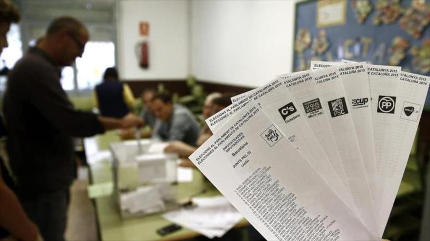 Una persona muestra las papeletas de los diferentes partidos que concurren a las elecciones que se celebraban en 2015 en Cataluña.