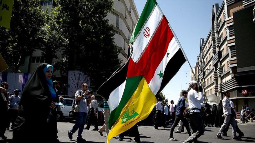 Un ciudadano iraní lleva banderas de Irán, Siria, Palestina y el Movimiento de la Resistencia Islámica de El Líbano (Hezbolá), 23 de junio de 2017.