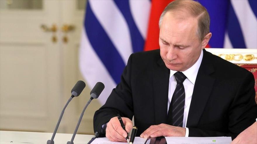 El presidente de Rusia, Vladimir Putin, firma documentos en el Kremlin.