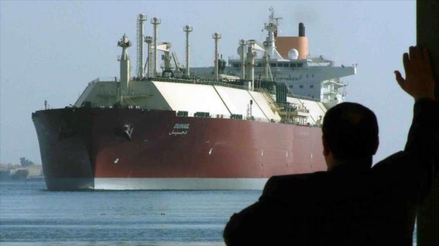 Un hombre ve cómo la mayor cisterna de gas natural licuado (LNG) del mundo, DUHAIL, de Catar, atraviesa el Canal de Suez, 1 de abril de 2008.