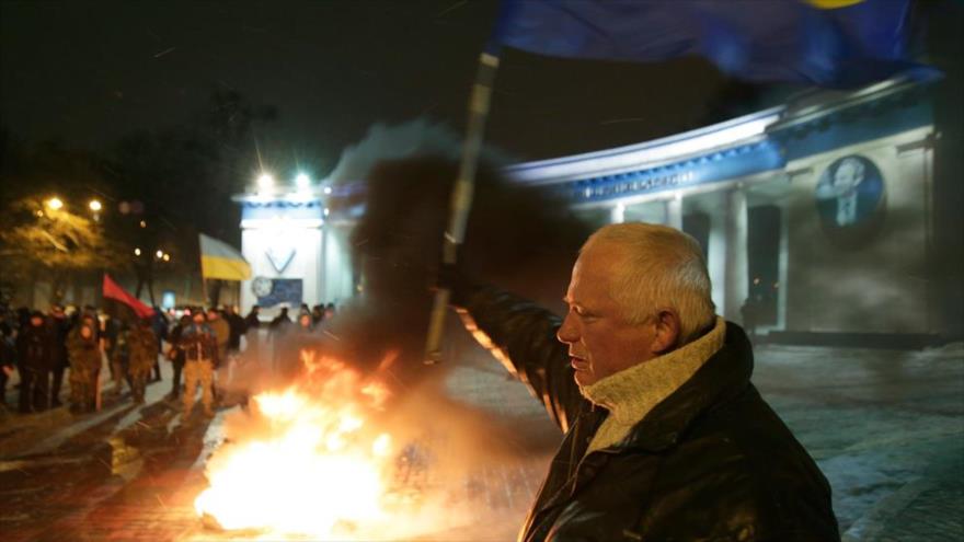 Miembros y simpatizantes de la Organización de Nacionalistas Ucranianos (OUN, en ucraniano) ondean la bandera de Ucrania y queman neumáticos en el centro de Kiev, capital ucraniana.