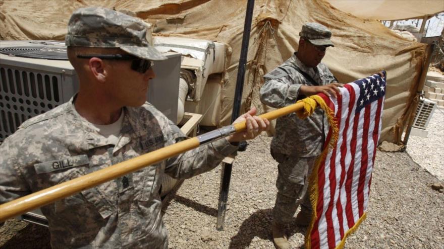 Soldados de EE.UU. doblan su bandera nacional antes de entregar su base a las fuerzas iraquíes en la provincia sureña de Basora, 22 de junio de 2011.