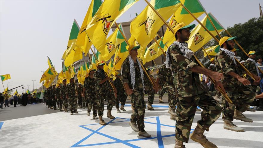 Fuerzas del Hezbolá de Irak pisotean una bandera israelí durante un desfiles militar.