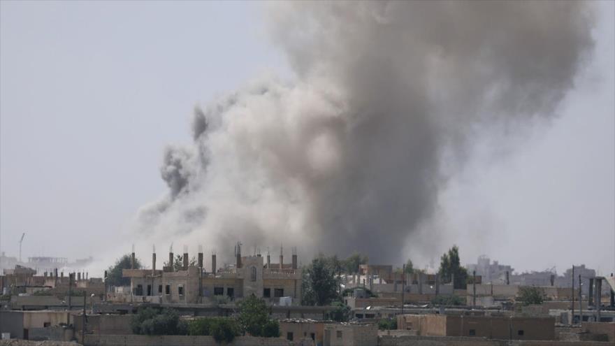 Humo levantado de un ataque aéreo de la coalición internacional, dirigida por EE.UU. en la ciudad siria de Al-Raqa.