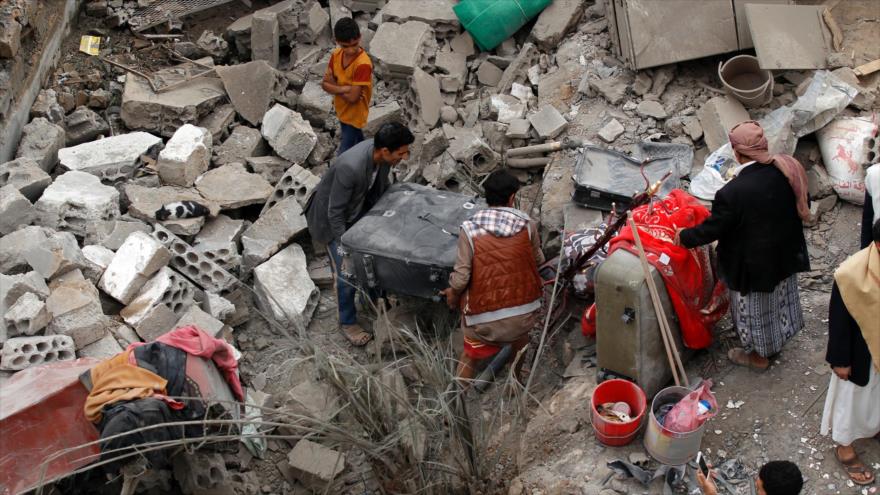 Yemeníes se encuentran entre los escombros de viviendas destruidas en un ataque aéreo de Arabia Saudí y sus aliados en Saná, 9 de junio de 2017.