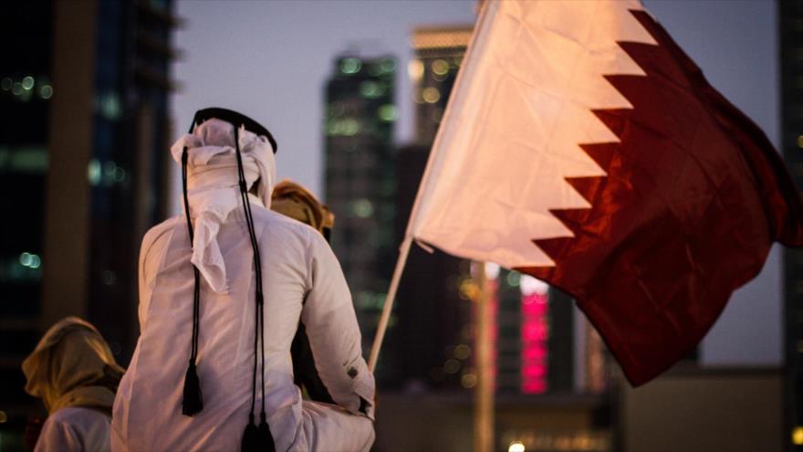Un ciudadano catarí sujeta la bandera nacional del país durante una marcha en la capitalina ciudad de Doha.